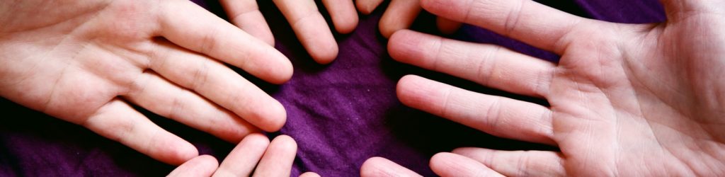 persons left hand on purple textile